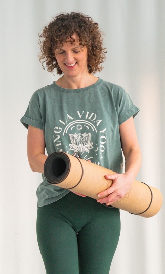 Julia Roggan stehend mit Yogamatte in den Händen